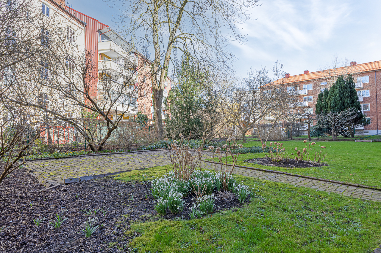 Trevlig innergård med stenlagd uteplats och gräsytor