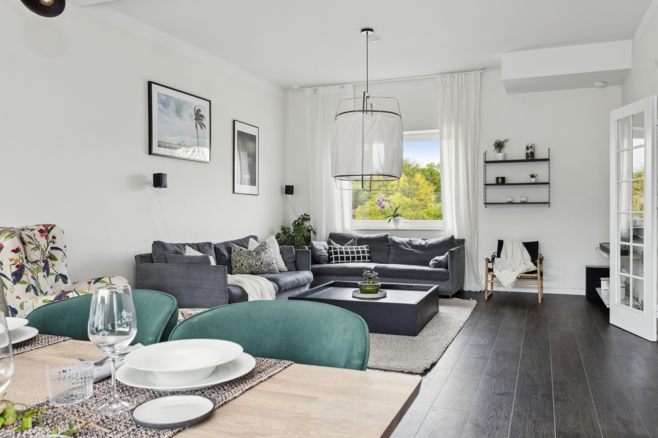Generöst vardagsrum med plats för både matsalsbord och en stor soffgrupp.